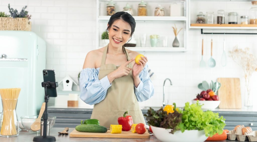 Seorang wanita Asia mengajarkan kelas memasak secara online.