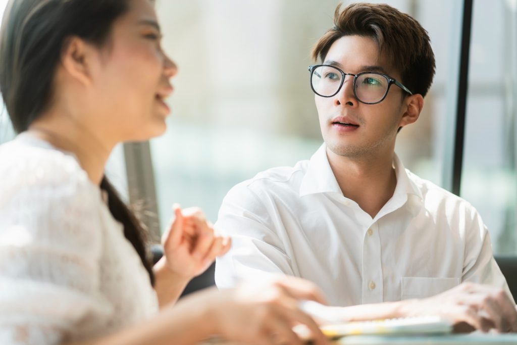 Seorang pria menatap rekan kerjanya saat rapat di kantor