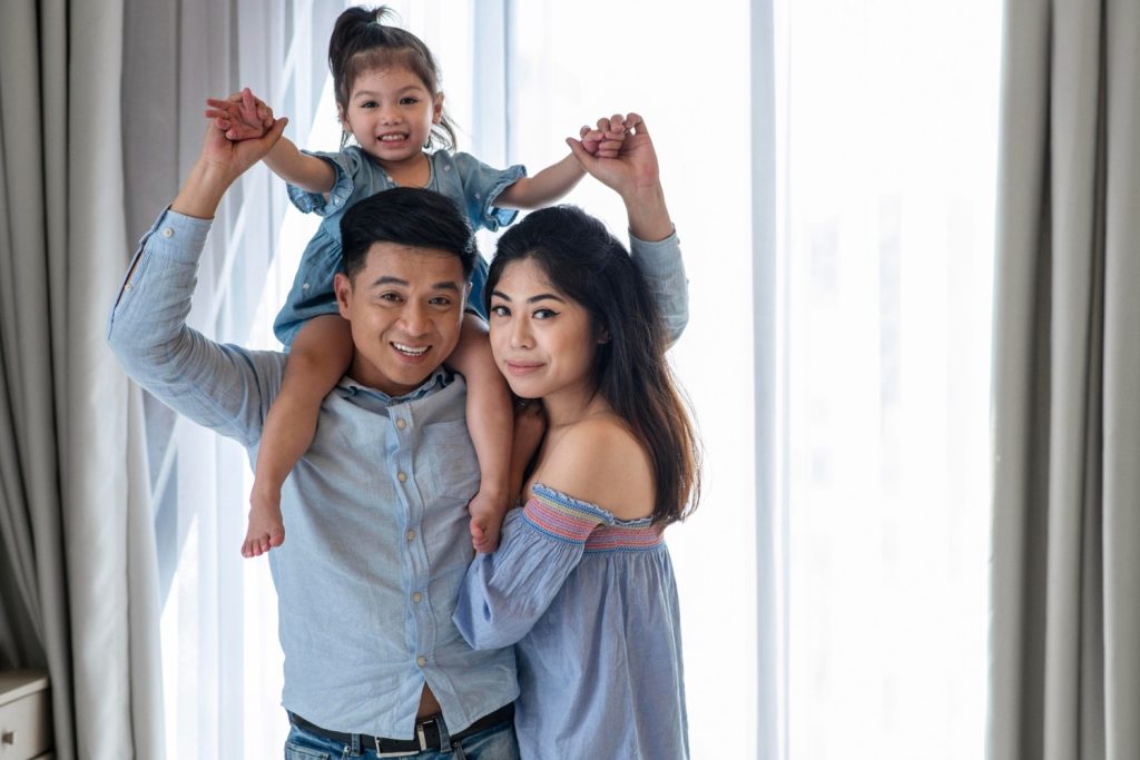 Sepasang suami dan istri menggendong anak perempuan mereka.