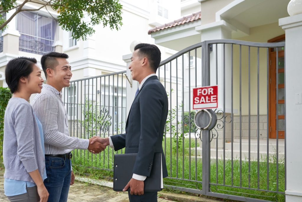 Pasangan suami istri bertemu dengan agen real estate dan berhasil membeli rumah.