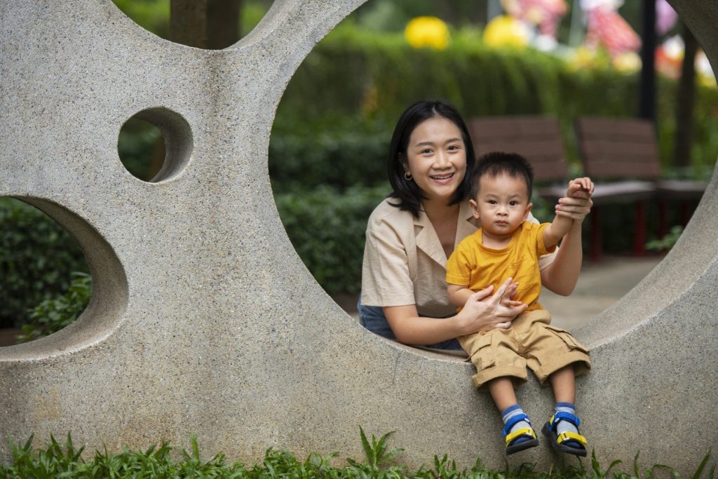 Seorang ibu muda bermain dengan anak laki-lakinya di taman.