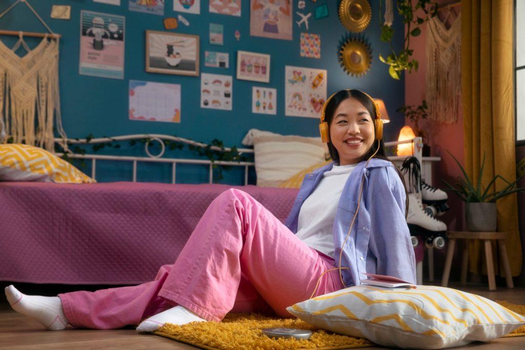 Seorang wanita Asia sedang bersantai di dalam kamar dengan gaya bohemian.