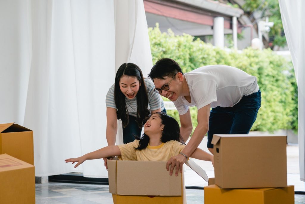 Keluarga Asia dengan satu anak sedang pindahan rumah.