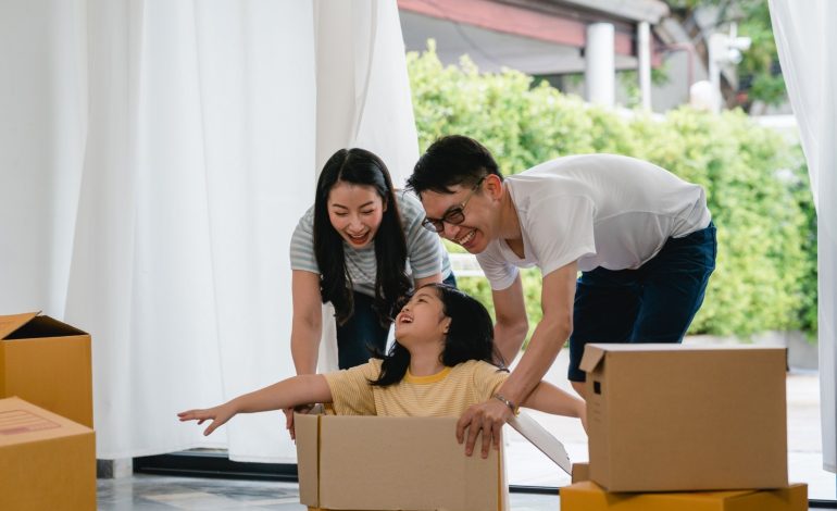 Keluarga Asia dengan satu anak sedang pindahan rumah.