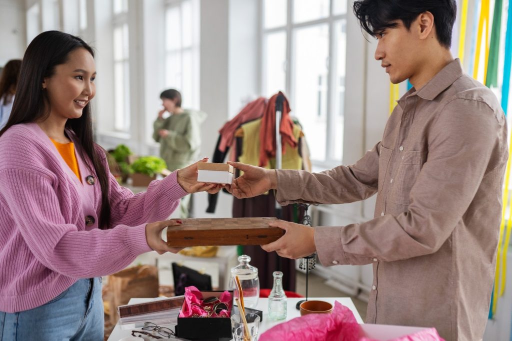 Laki-laki menjual barang dagangannya ke seorang wanita.