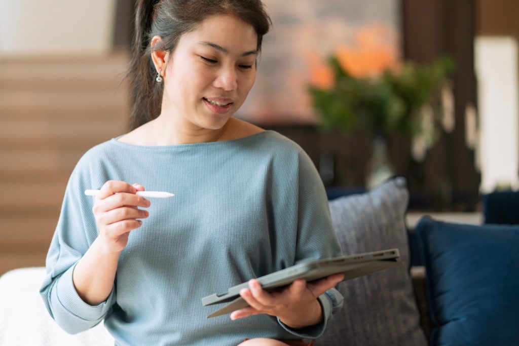 Seorang wanita sedang menyusun anggaran pribadi di tabletnya.