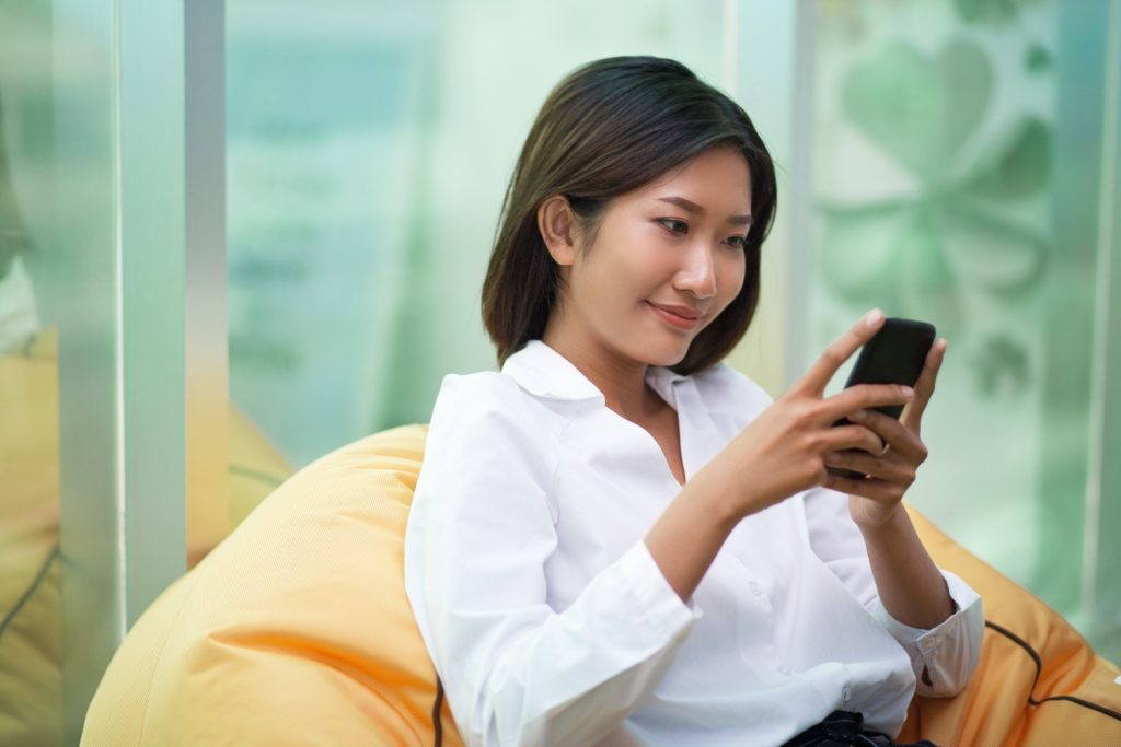 Seorang wanita melihat cara pengajuan Danakini Finance melalui aplikasi.