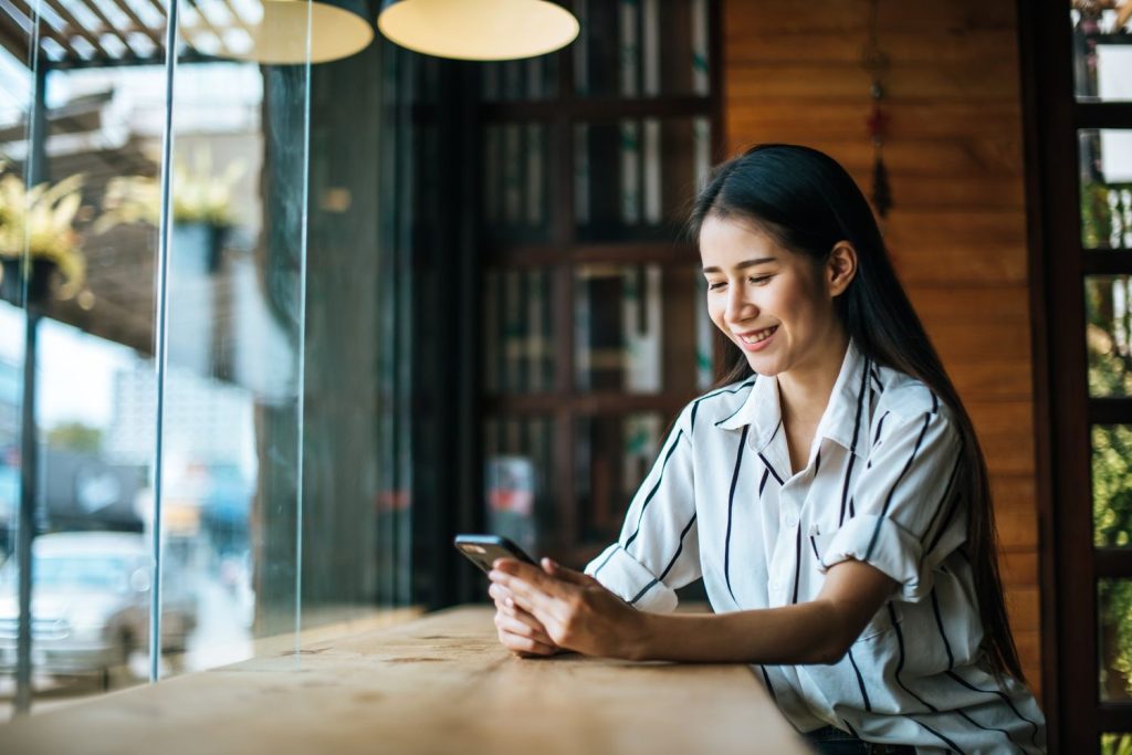 Seorang wanita sedang melakukan pembayaran melalui mobile banking.