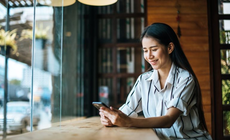 Seorang wanita sedang melakukan pembayaran melalui mobile banking.