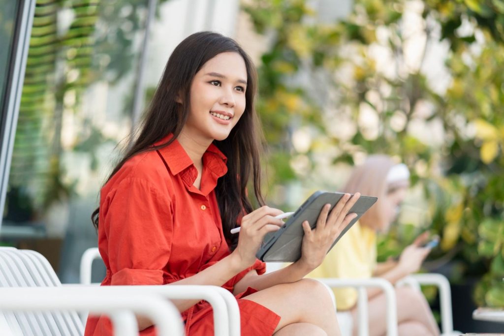 Seorang wanita sedang bekerja menggunakan tablet.