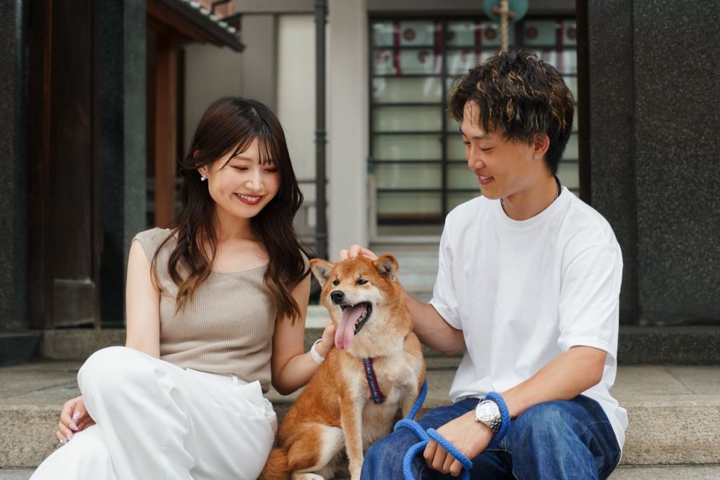 Pasangan kekasih bermain dengan anjing lucu di taman.