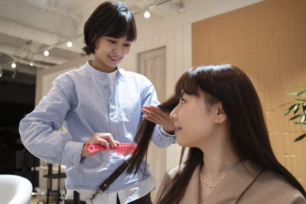 Rambut seorang wanita sedang digunting oleh hairdresser profesional di salon
