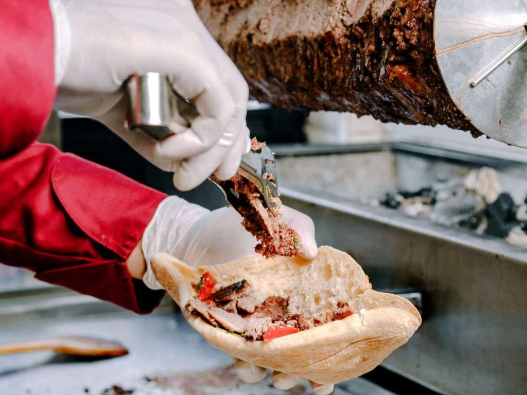 Seorang penjual makanan menyajikan kebab Turki