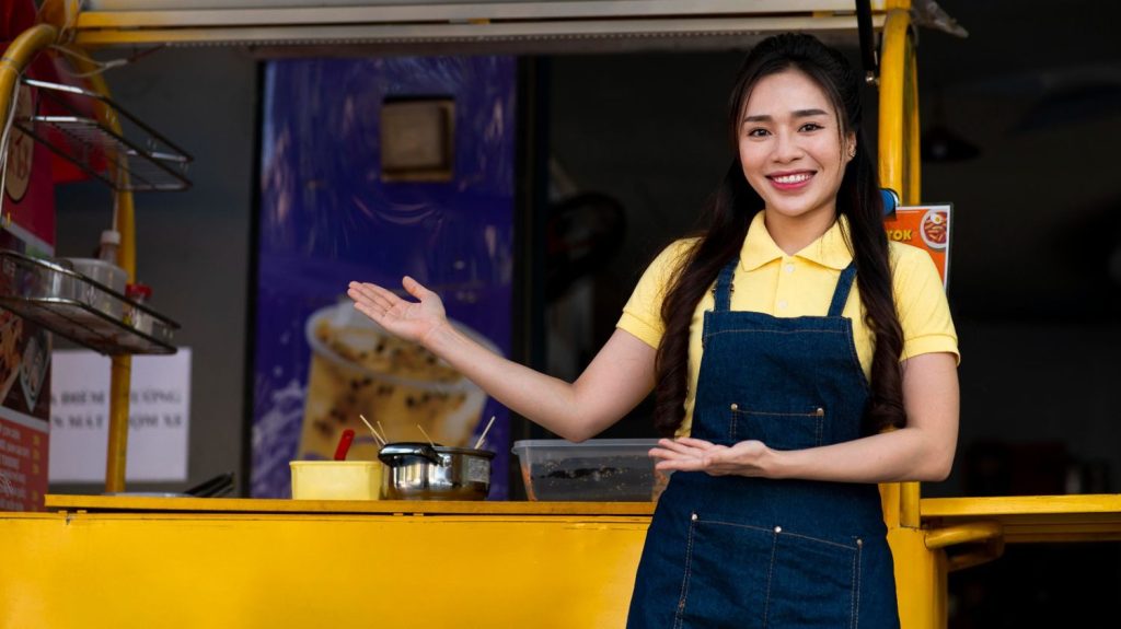 Seorang wanita menunjukkan food truck franchise miliknya