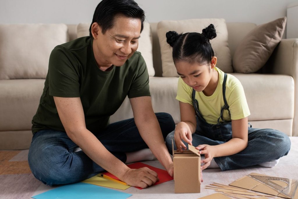 Seorang ayah dan anak perempuan sedang merakit box bersama