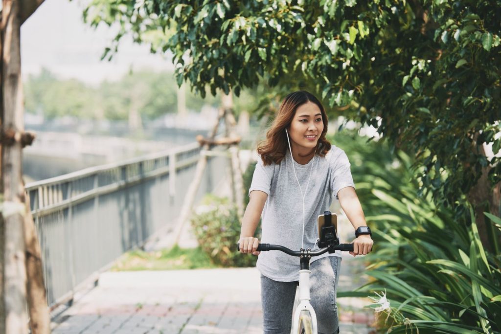 Seorang wanita sedang bersepeda di taman