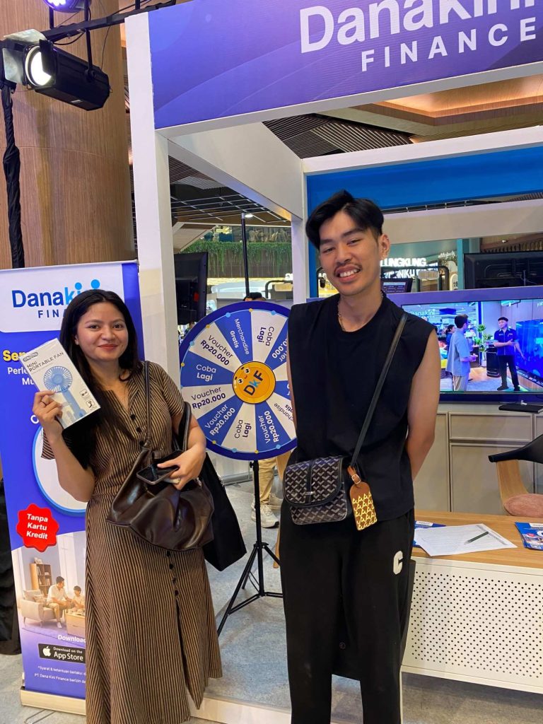 pengunjung yang berhasil memenangkan merchandise eksklusif Danakini Finance dari main game spin the wheel di booth Danakini Finance di acara Multifinance Day 2026 di Main Atrium Living World Denpasar