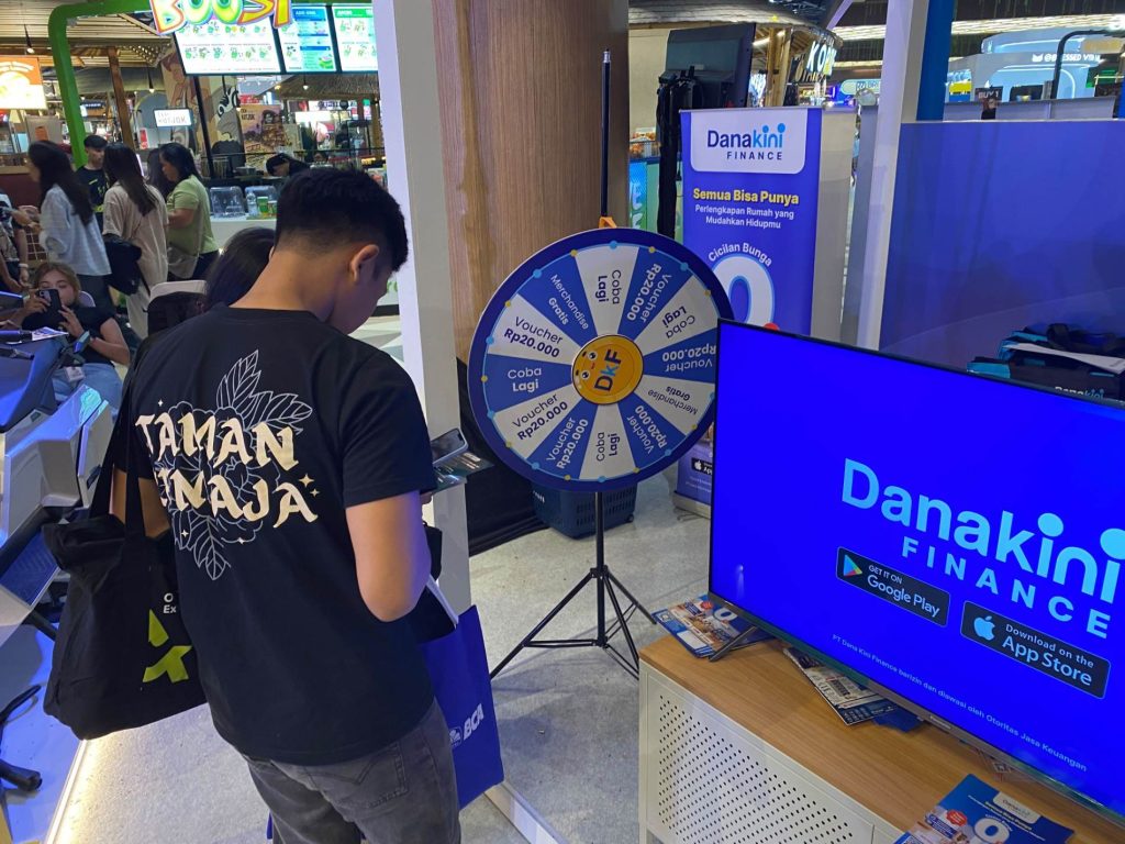 pengunjung sedang download aplikasi Danakini Finance dan melakukan registrasi di depan booth Danakini Finance di acara Multifinance Day 2026 di Main Atrium Living World Denpasar, Bali